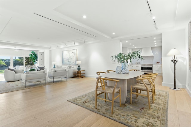 dining room with baseboards, track lighting, and light wood-style floors