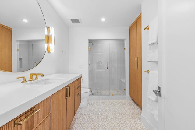 bathroom featuring vanity, toilet, and a shower with door