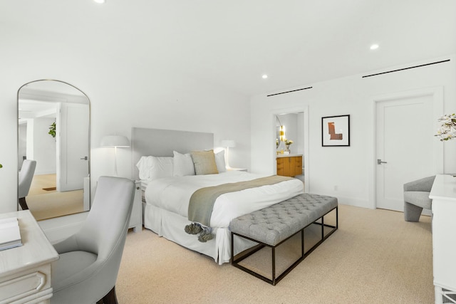 bedroom with light carpet, ensuite bath, and recessed lighting