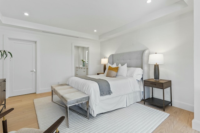 bedroom with baseboards, light wood-type flooring, and recessed lighting