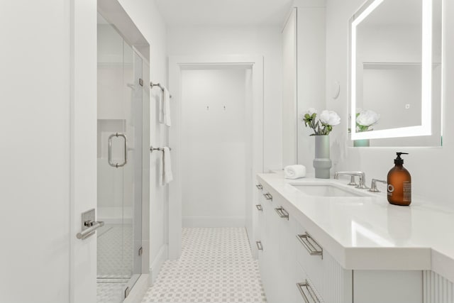 full bath with baseboards, a stall shower, vanity, and tile patterned floors