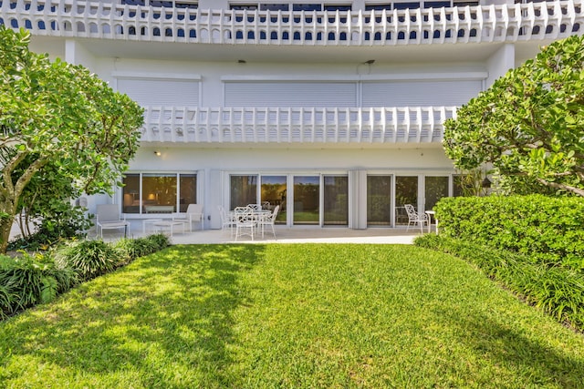 rear view of house featuring a yard and a patio