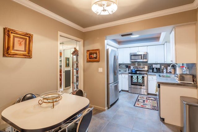 kitchen with white cabinets, sink, ornamental molding, and stainless steel appliances