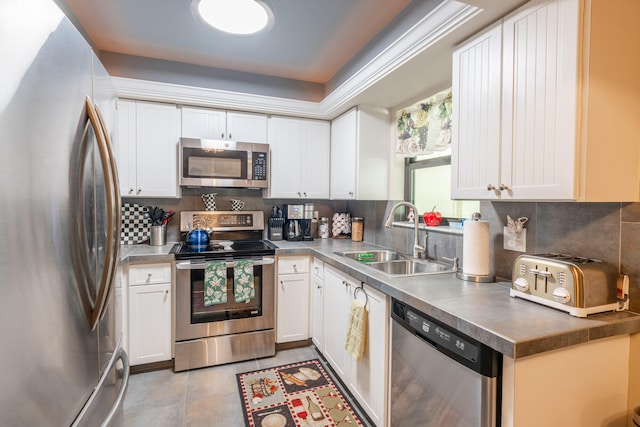 kitchen with white cabinets, decorative backsplash, sink, and stainless steel appliances