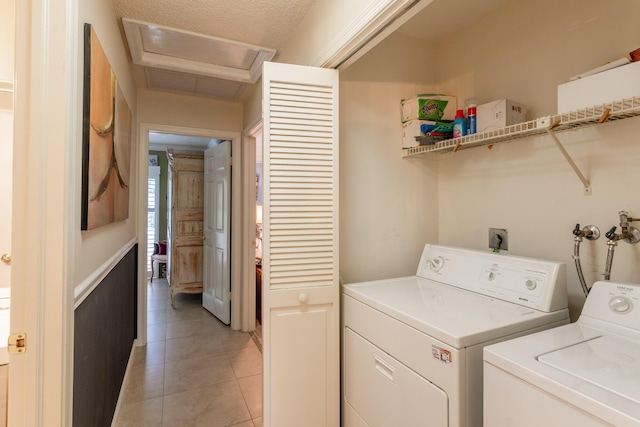 clothes washing area featuring independent washer and dryer, a textured ceiling, and light tile patterned floors