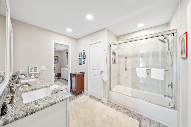 bathroom featuring shower / bath combination with glass door, hardwood / wood-style floors, and vanity