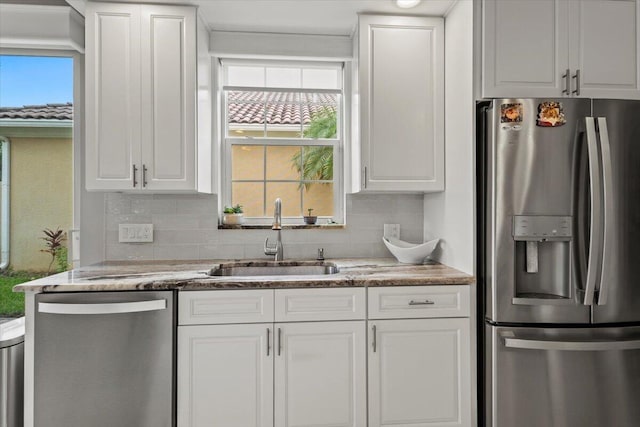 kitchen with white cabinets, a wealth of natural light, appliances with stainless steel finishes, and sink