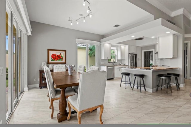 dining space featuring sink and crown molding