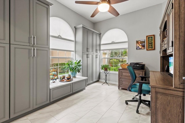 tiled office space featuring ceiling fan and a healthy amount of sunlight