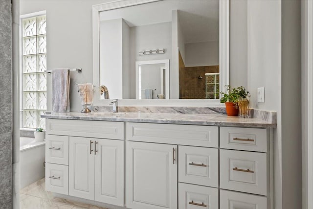 bathroom featuring tile patterned flooring, an enclosed shower, and vanity