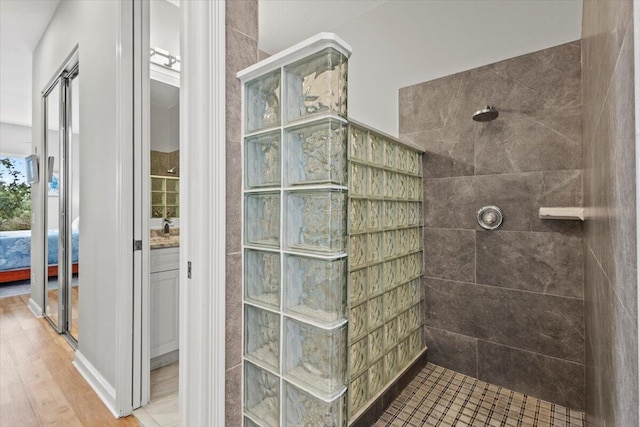 bathroom with vanity, wood-type flooring, and tiled shower