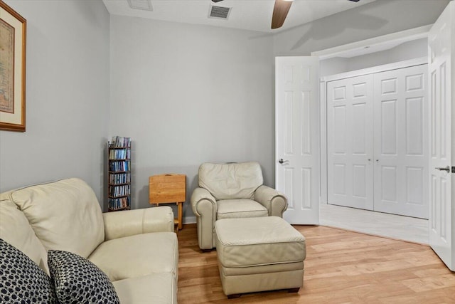 living area featuring light hardwood / wood-style floors and ceiling fan