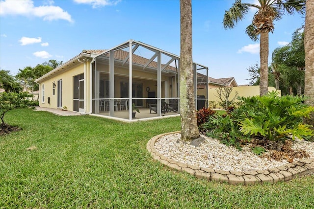 back of property featuring a lawn and a lanai