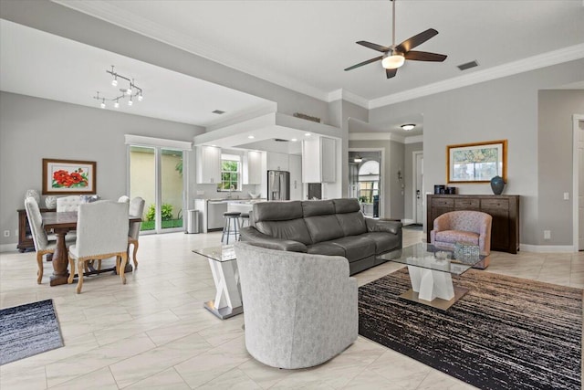 living room featuring ornamental molding and ceiling fan with notable chandelier