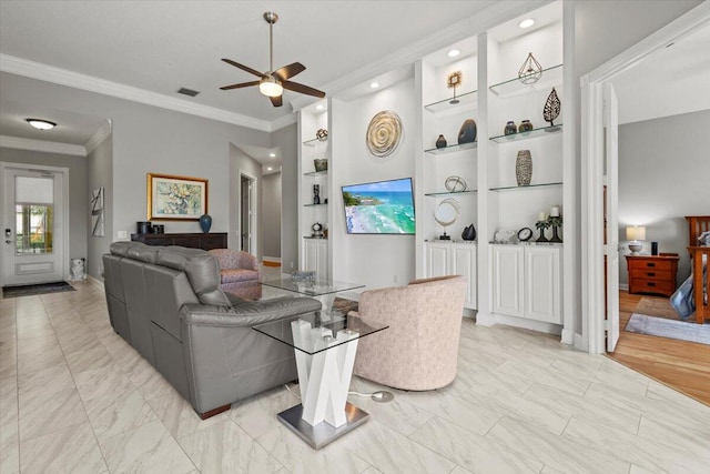 living room with light hardwood / wood-style floors, built in features, ceiling fan, and crown molding