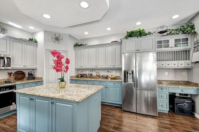 kitchen featuring appliances with stainless steel finishes, dark wood-type flooring, and a center island