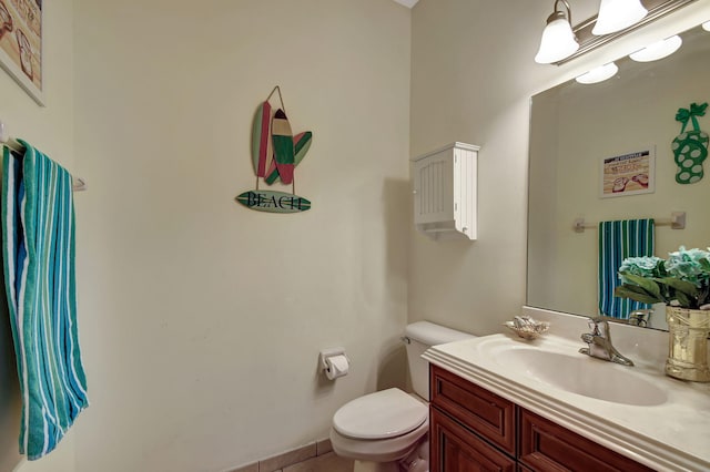 bathroom with tile patterned flooring, vanity, and toilet