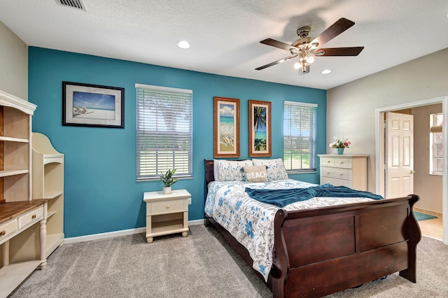 bedroom featuring multiple windows, a textured ceiling, carpet, and ceiling fan