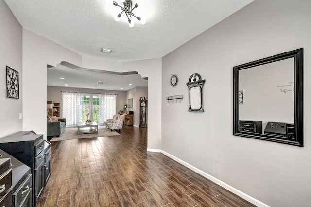 hallway with dark wood-type flooring and a textured ceiling