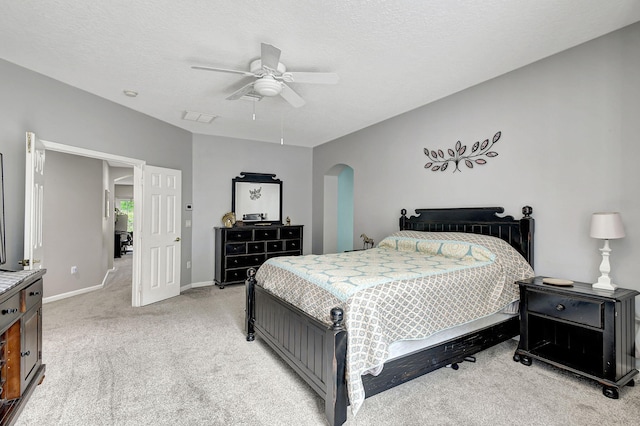 carpeted bedroom featuring a textured ceiling and ceiling fan