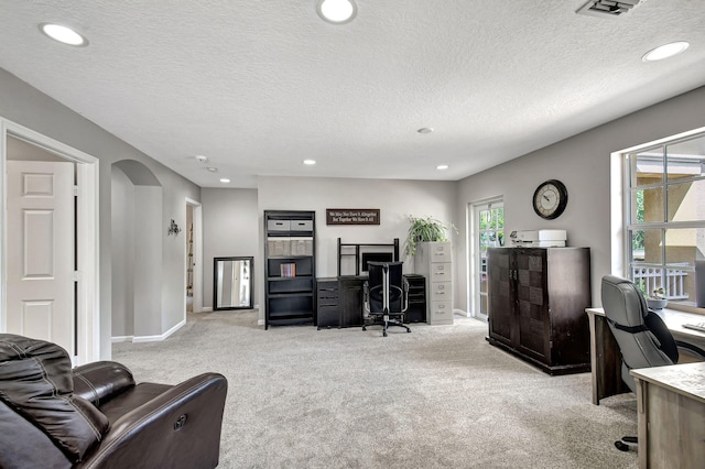 office area featuring a textured ceiling and light colored carpet