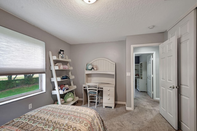 bedroom featuring a textured ceiling and light carpet