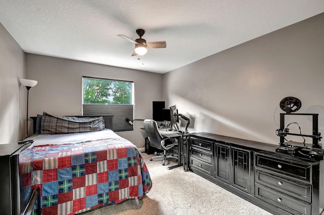 bedroom featuring a textured ceiling, light colored carpet, and ceiling fan