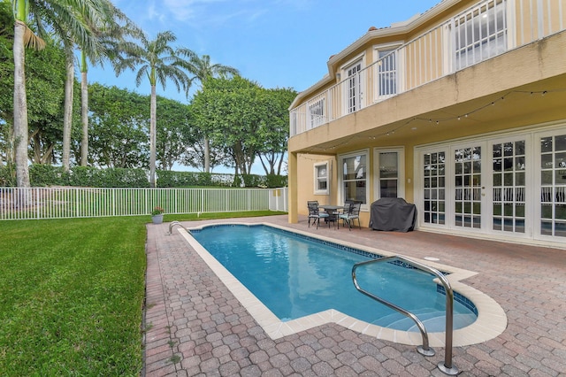 view of swimming pool featuring a patio, grilling area, and a yard