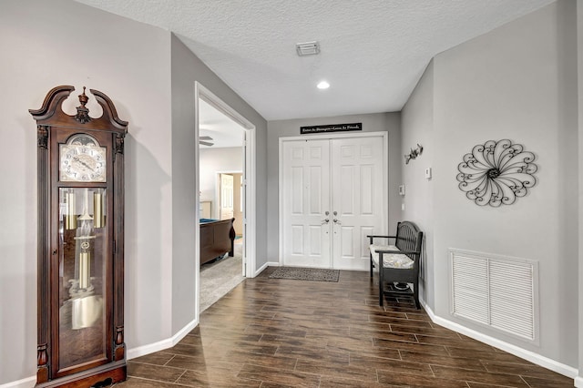 foyer entrance with dark hardwood / wood-style flooring and a textured ceiling