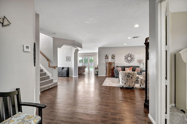 bedroom featuring decorative columns and a textured ceiling