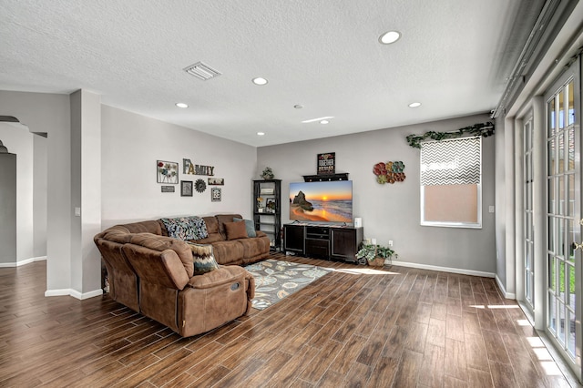 living room with dark hardwood / wood-style floors and a textured ceiling