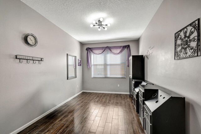 interior space with a chandelier, a textured ceiling, and dark hardwood / wood-style flooring