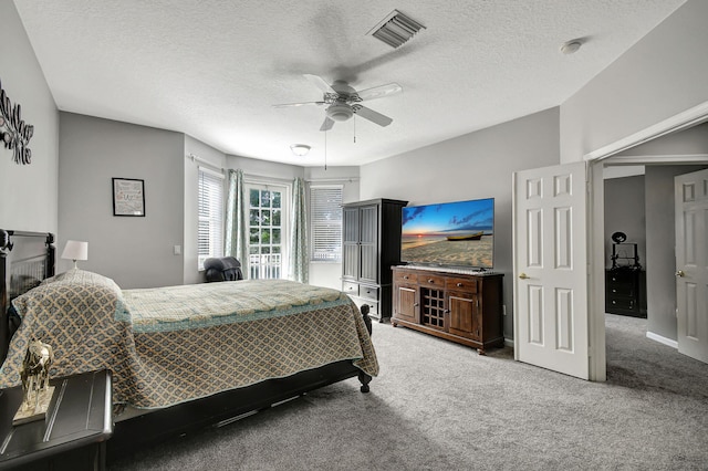 carpeted bedroom featuring a textured ceiling and ceiling fan