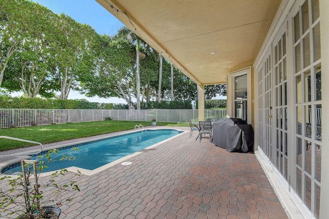 view of pool featuring grilling area, a yard, and a patio area