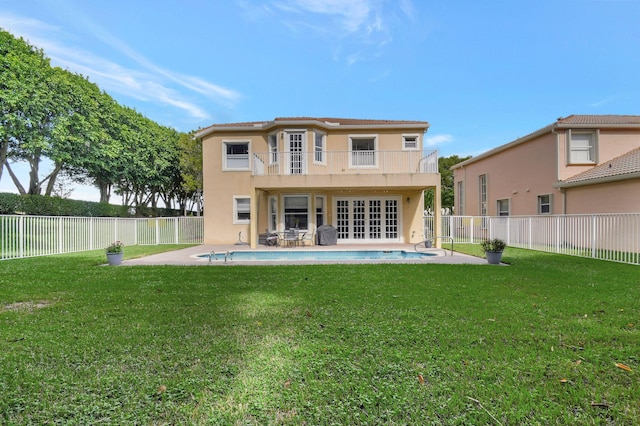 back of house featuring a patio, a yard, and a balcony