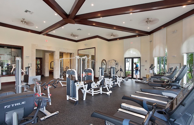 gym featuring french doors, ceiling fan, and a towering ceiling