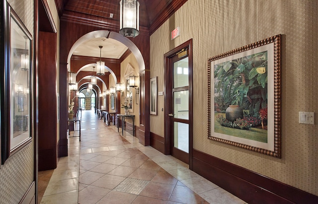 hall with light tile patterned floors and ornamental molding