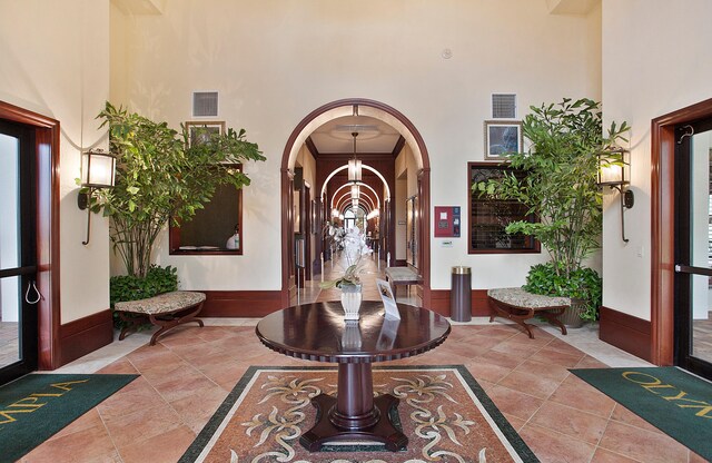 foyer featuring ornamental molding, french doors, a high ceiling, and an inviting chandelier