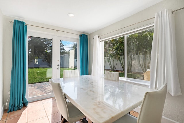 tiled dining space featuring french doors