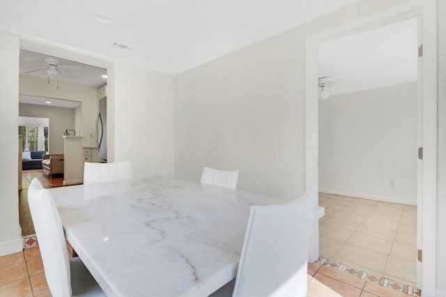 dining space featuring ceiling fan and light tile patterned floors