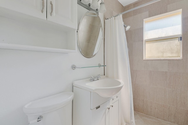 bathroom featuring toilet, curtained shower, vanity, and tile patterned flooring