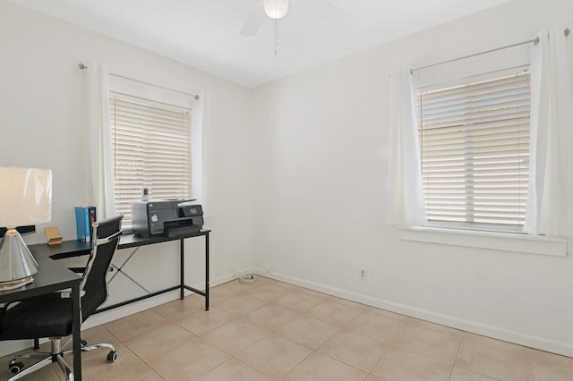 home office featuring ceiling fan, light tile patterned flooring, and a wealth of natural light