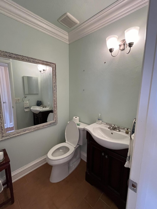 bathroom with crown molding, visible vents, toilet, vanity, and baseboards