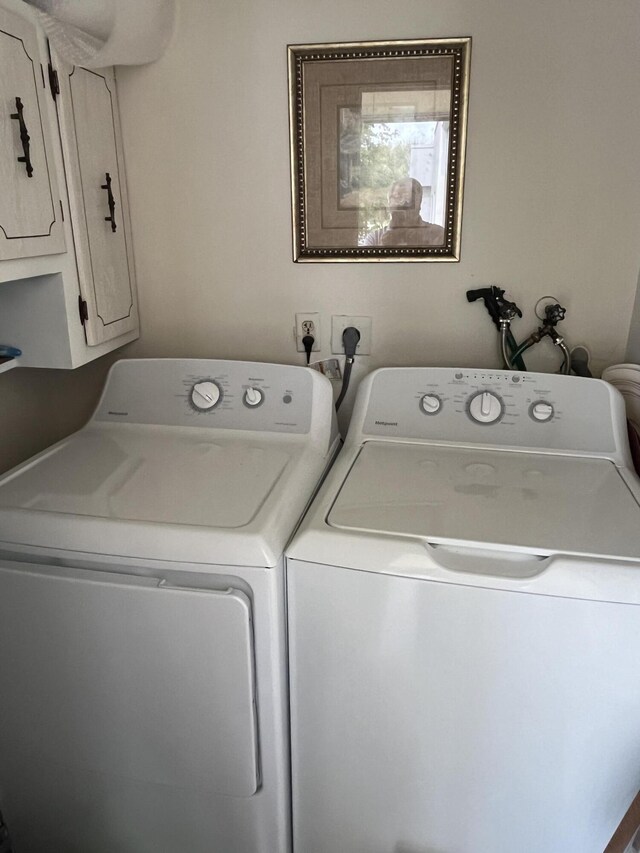 washroom featuring washing machine and dryer and cabinet space