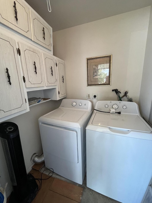 clothes washing area featuring washing machine and clothes dryer and cabinet space