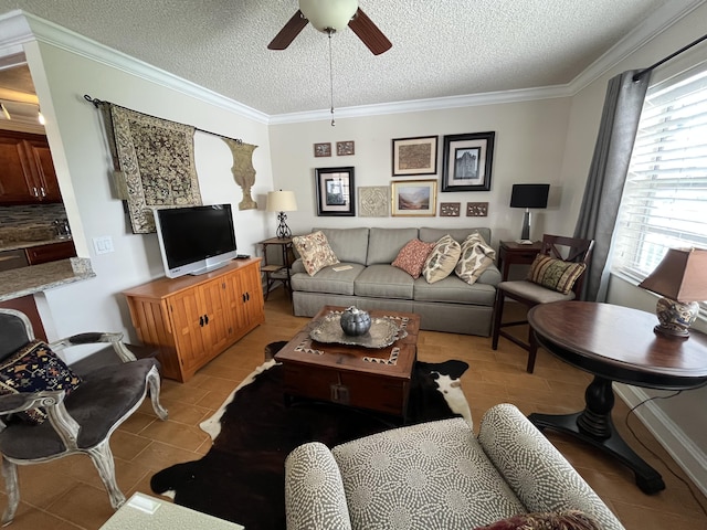 living area with light tile patterned floors, crown molding, a textured ceiling, and ceiling fan