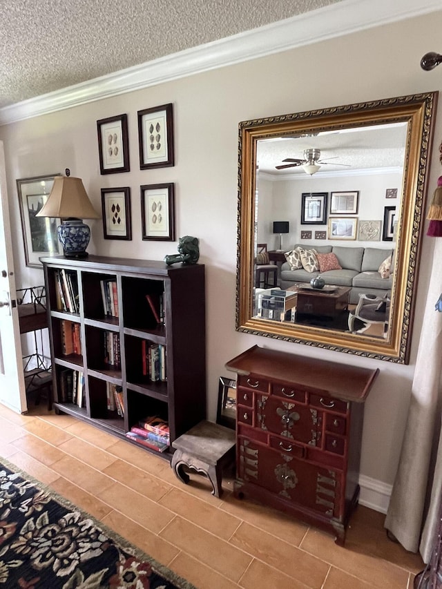 sitting room with a textured ceiling, ceiling fan, and ornamental molding