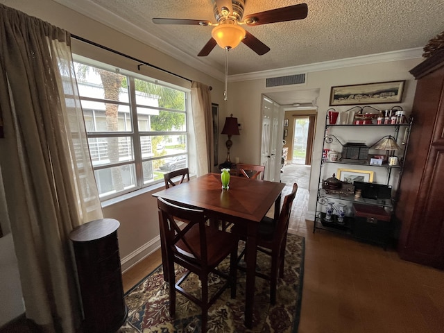 dining area with a textured ceiling, ceiling fan, ornamental molding, and visible vents