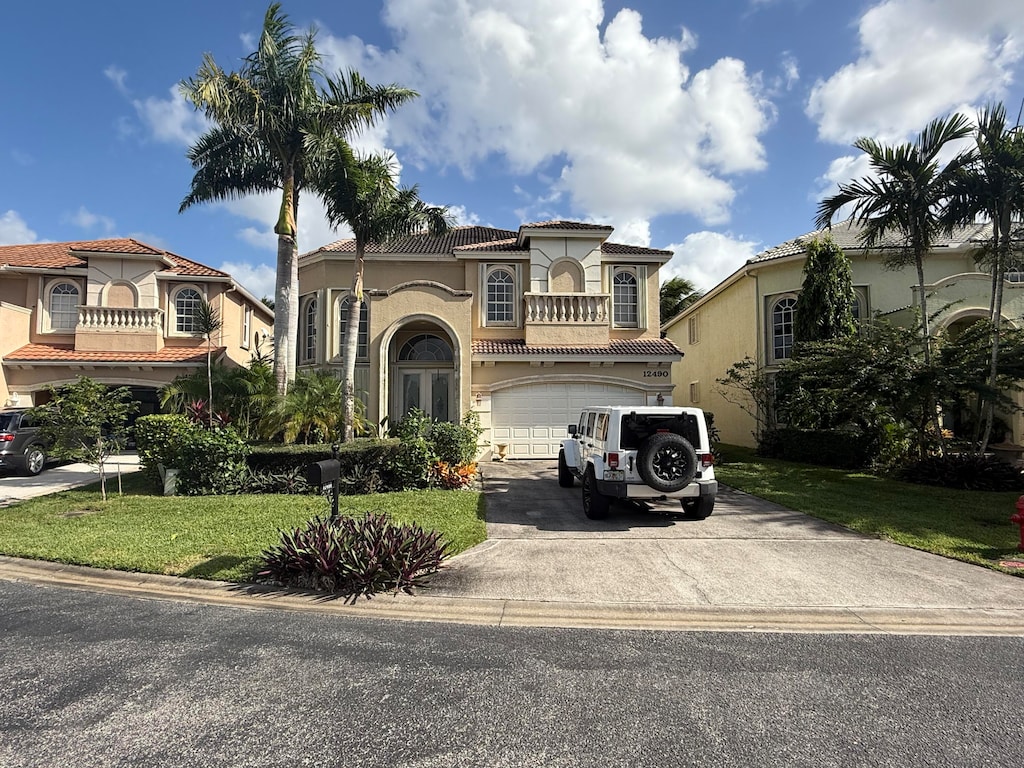 mediterranean / spanish-style house featuring a front yard and a garage