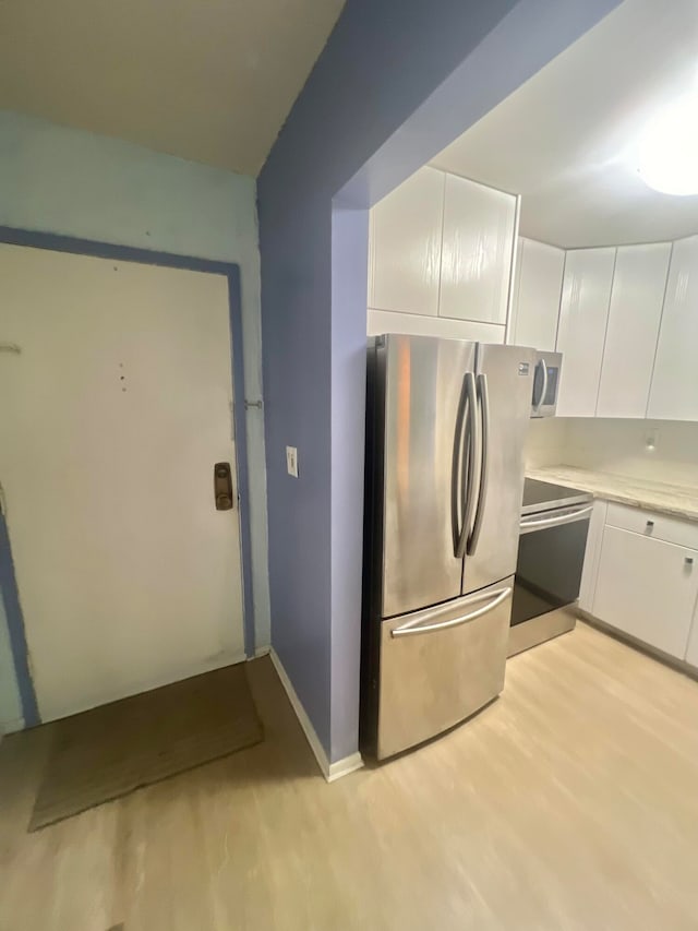 kitchen featuring white cabinetry, light wood-type flooring, and appliances with stainless steel finishes